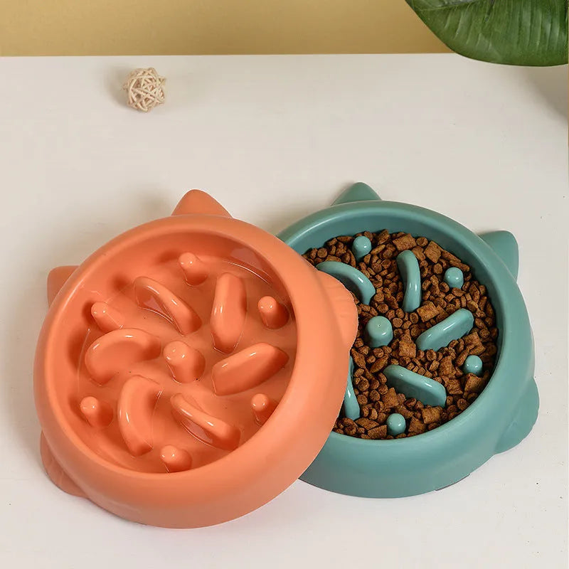 Green bone-ridge slow feeder bowl for dogs and cats on a floor.