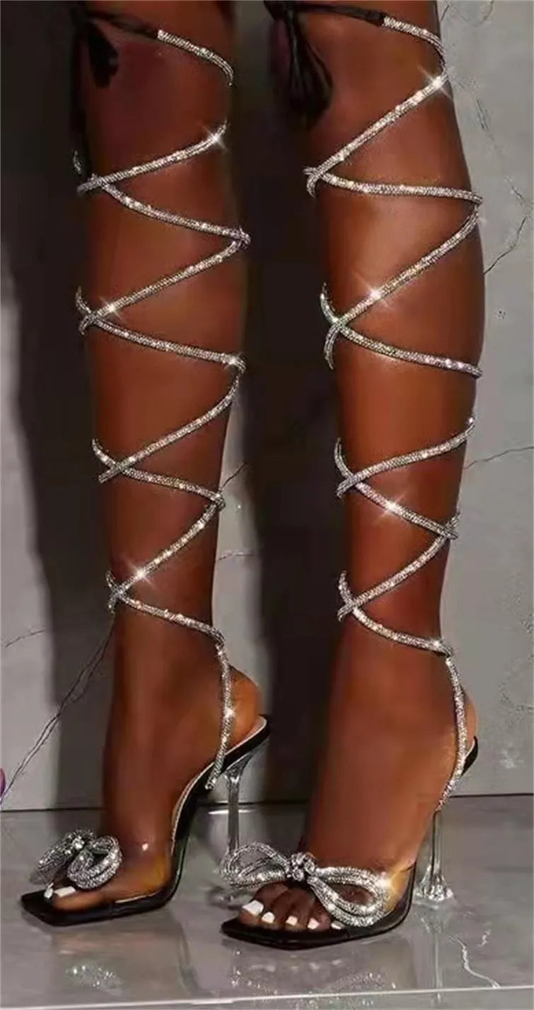 Plus size black strappy sandals with rhinestone details and a square toe on a rubber sole.