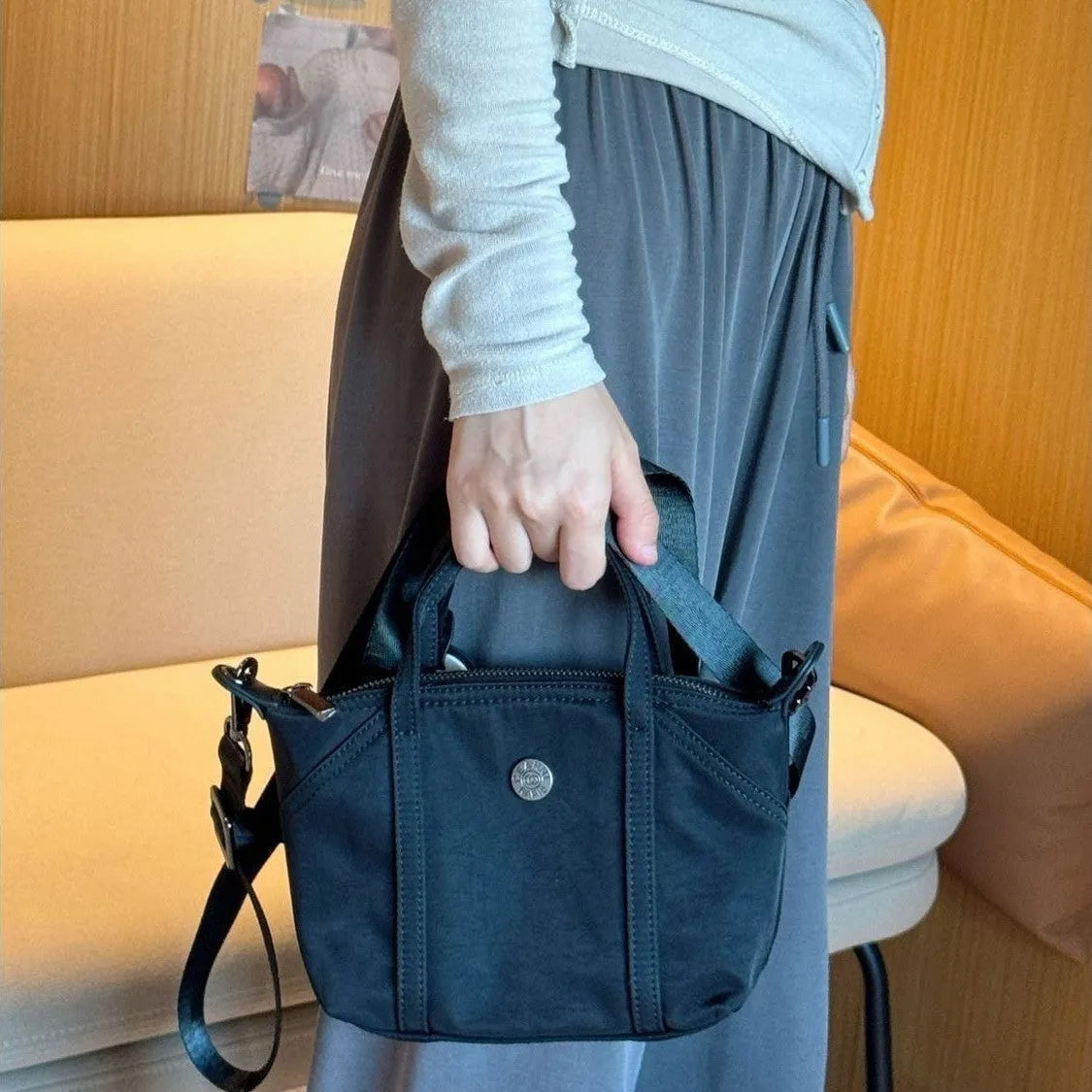 Casual lightweight nylon crossbody bag in dumpling shape, available colours black brown orange pink yellow, with pendant