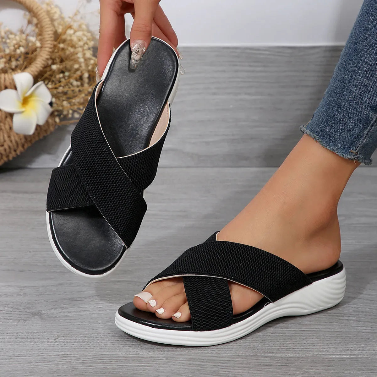 Black flat wedge peep-toe women's slippers with a cross-strap and thick rubber sole.