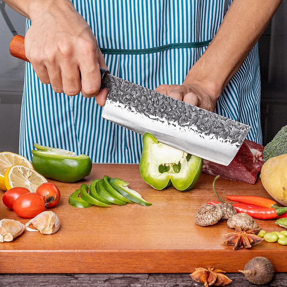 Handmade hammered forged stainless steel santoku chef knife with gift box packaging on a kitchen surface