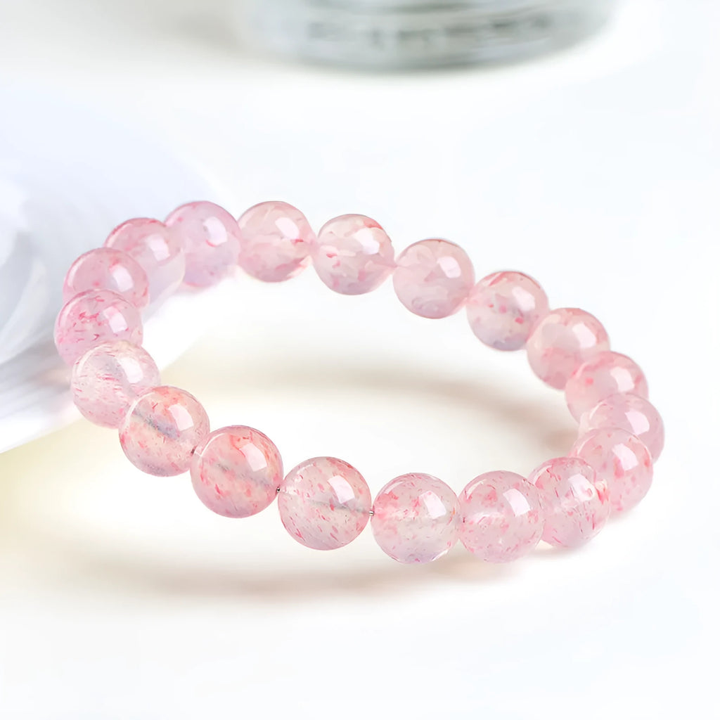 Natural white strawberry quartz crystal ball bracelet with 10mm spherical beads on wrist.