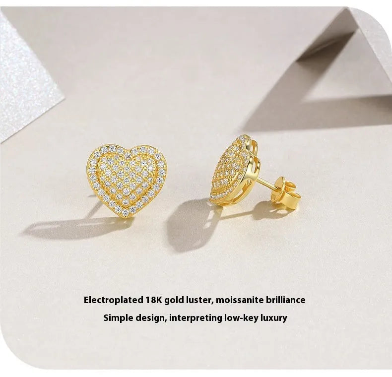 Golden heart-shaped stud earrings with moissanite stones on silver posts
