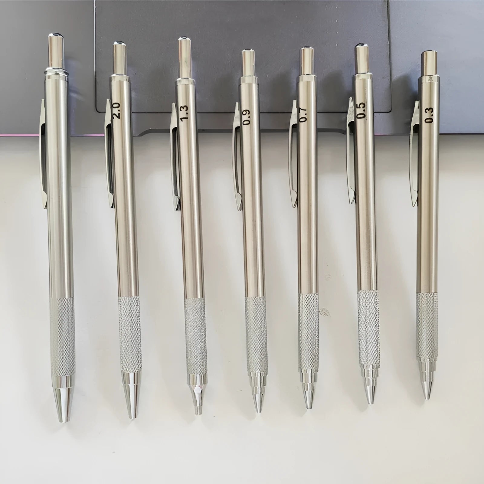 A metal automatic mechanical pencil with multiple lead size options including 0.5mm, 0.7mm, 0.9mm, 1.3mm, and 2.0mm.
