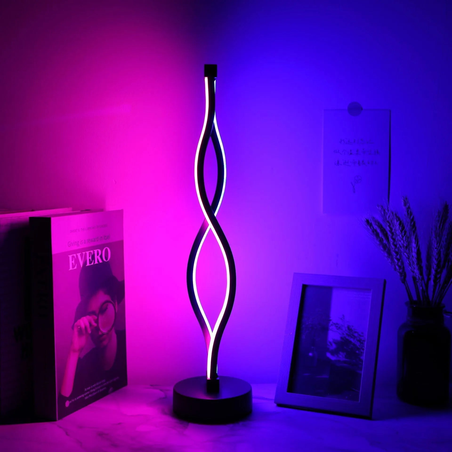 Black aluminium desk lamp on a table showing its three-colour dimming button and touch panel.