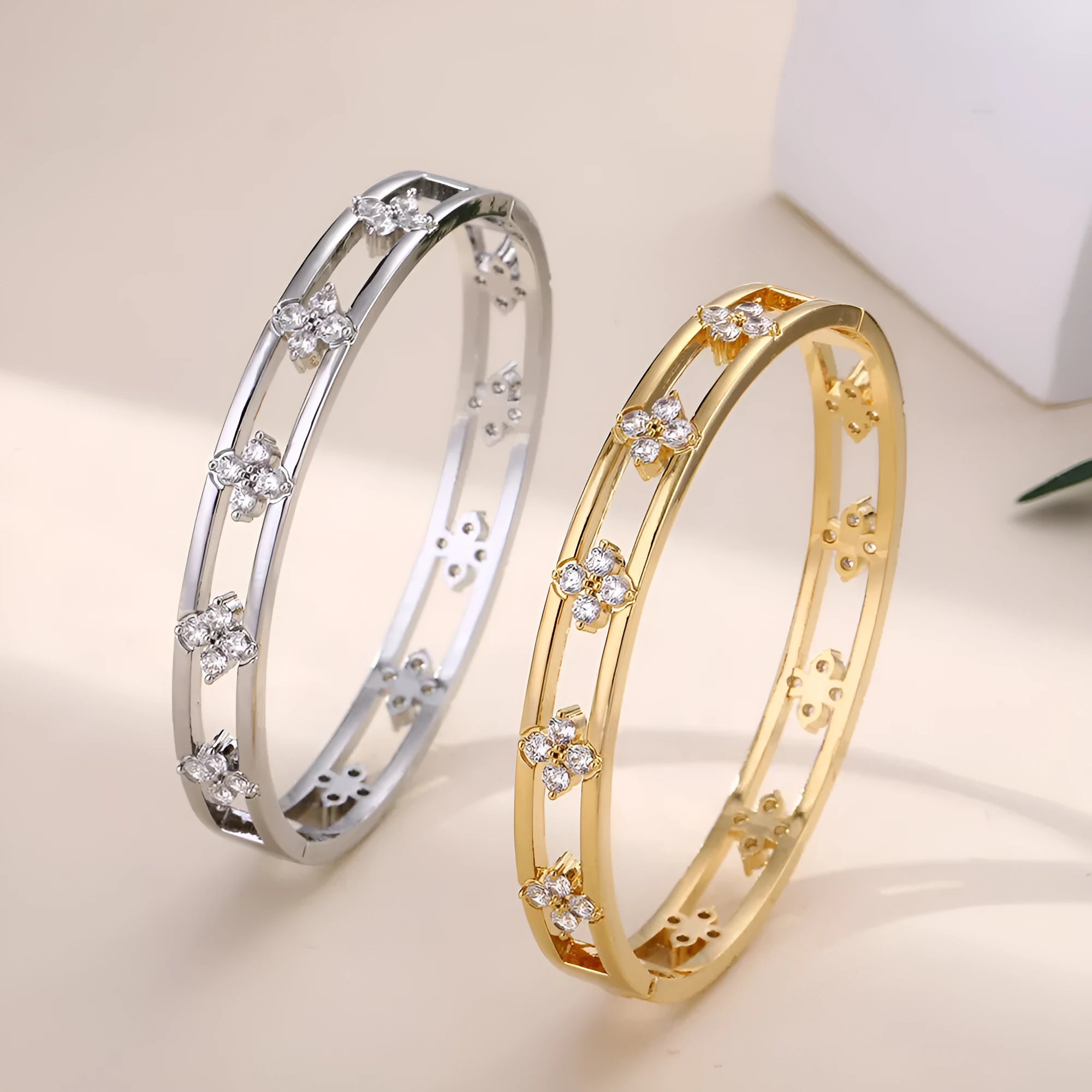 Gold or silver plated women's hollow bracelet with a four-leaf clover charm and zircon stones.