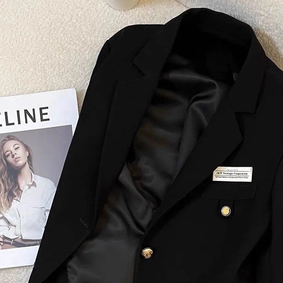 Women's black loose-fit short polyester suit coat with long sleeves and pockets.