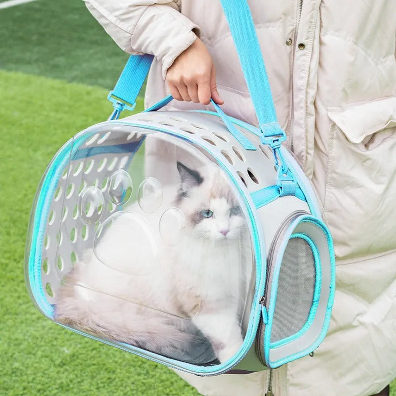 Transparent hard-shell space capsule backpack for a cat, shown in a choice of colours including grass green and pink.