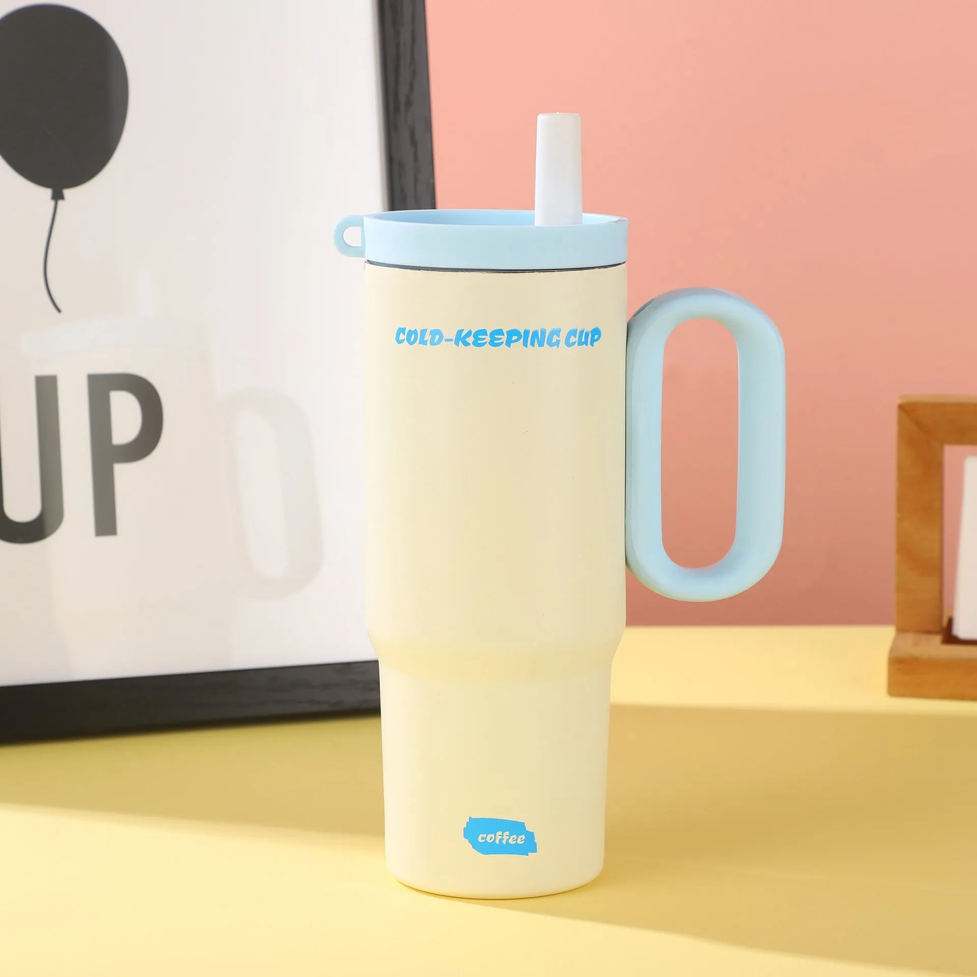 Insulated tumbler cup with a carrying handle and a straw, shown in one of five colour options.