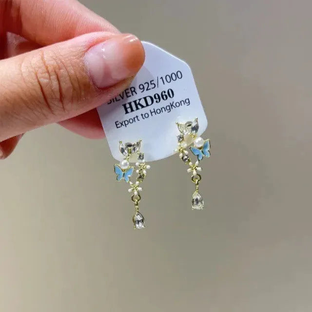 Geometric heart-shaped alloy ear clips with rhinestone accents and dangling star tassels in silver-tone