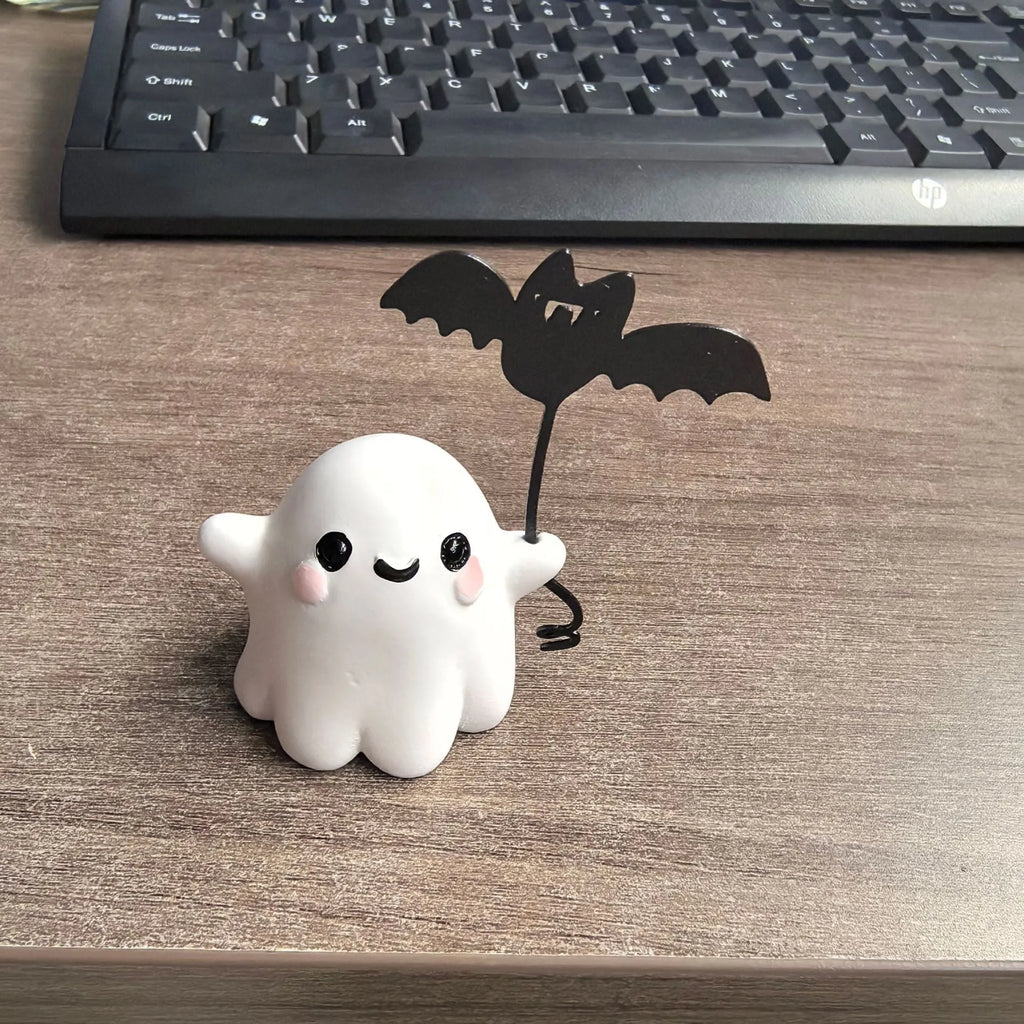 Small resin statue of a ghost walking a dog, holding a bat, for Halloween decoration.