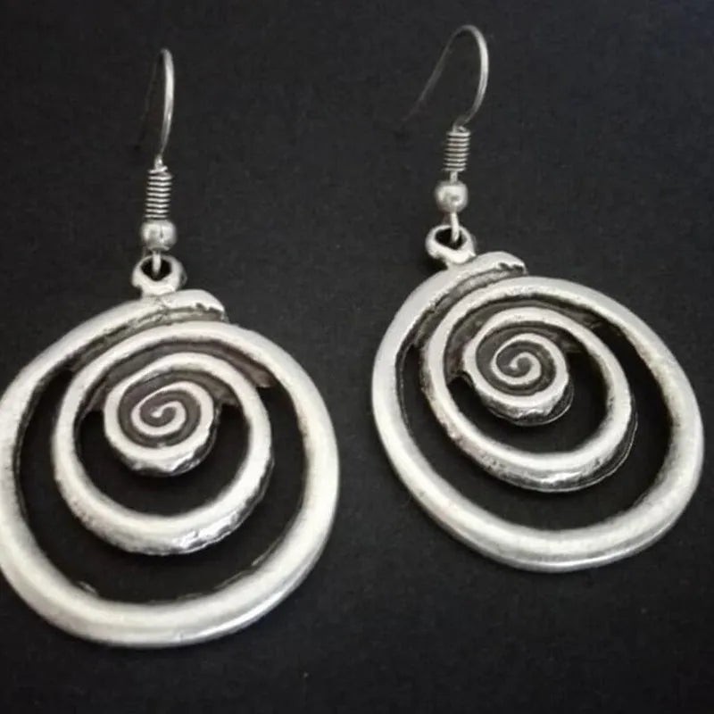 Silver geometric spiral earrings with a distressed retro finish, shown from the front.