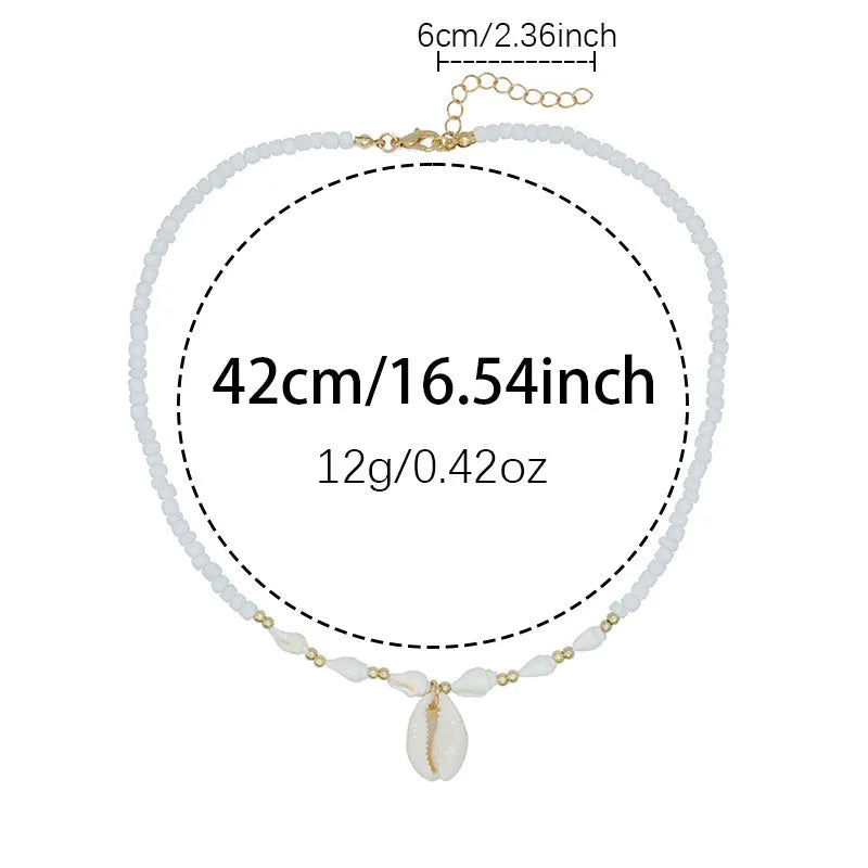 White conch shell pendant necklace with a cold wind pattern design on a silver-toned chain.