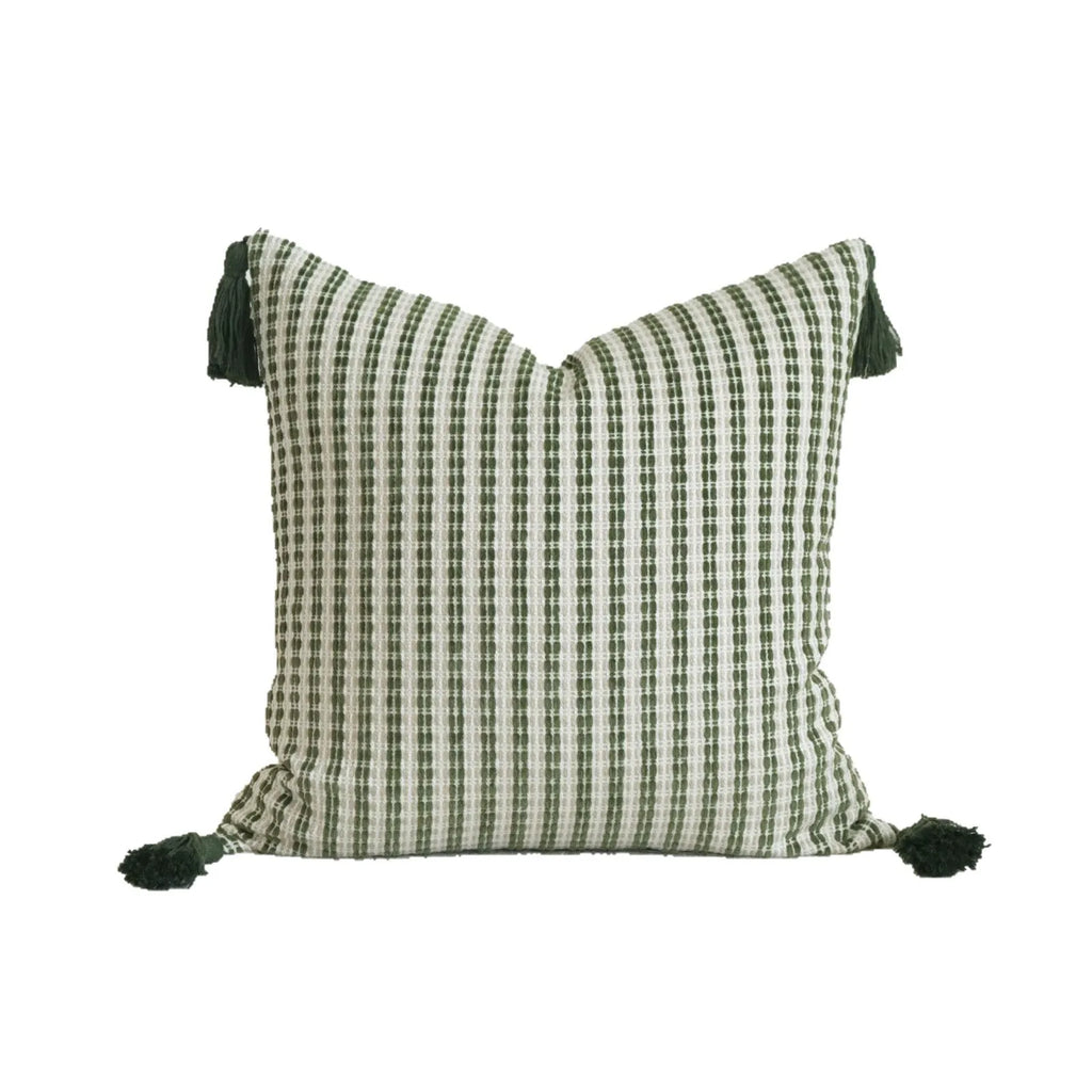 Green cotton linen hotel sample pillow with tassel design and silk floss filling on bed.