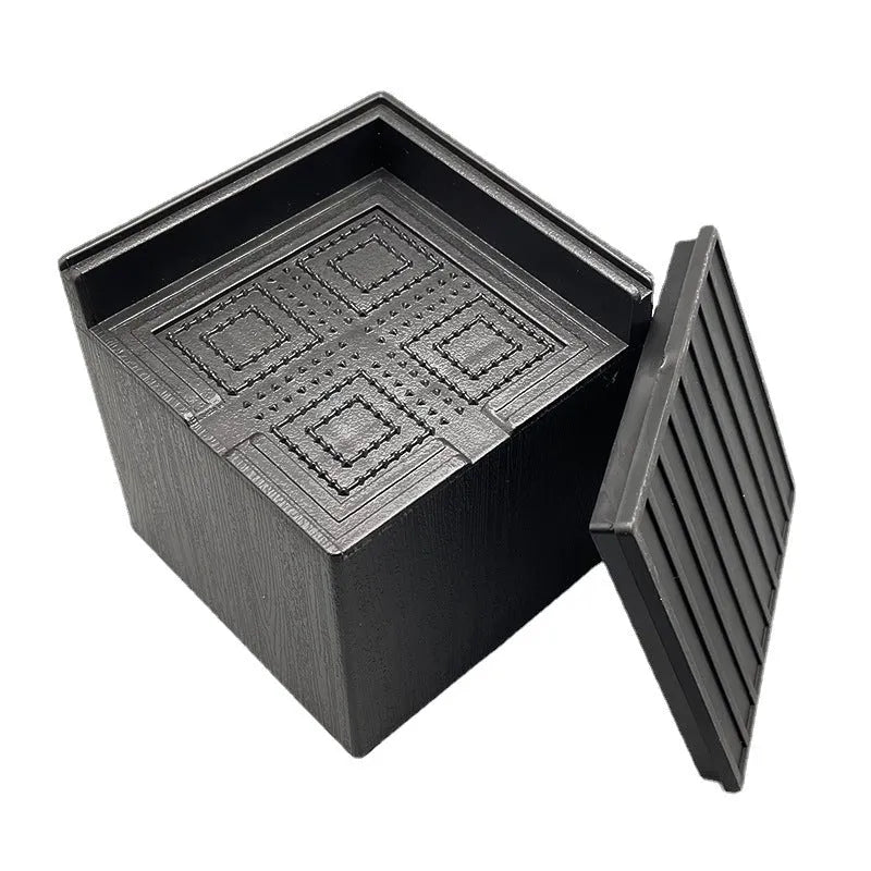 Four black thickened plastic bed foot mats arranged together for furniture height increase and floor protection