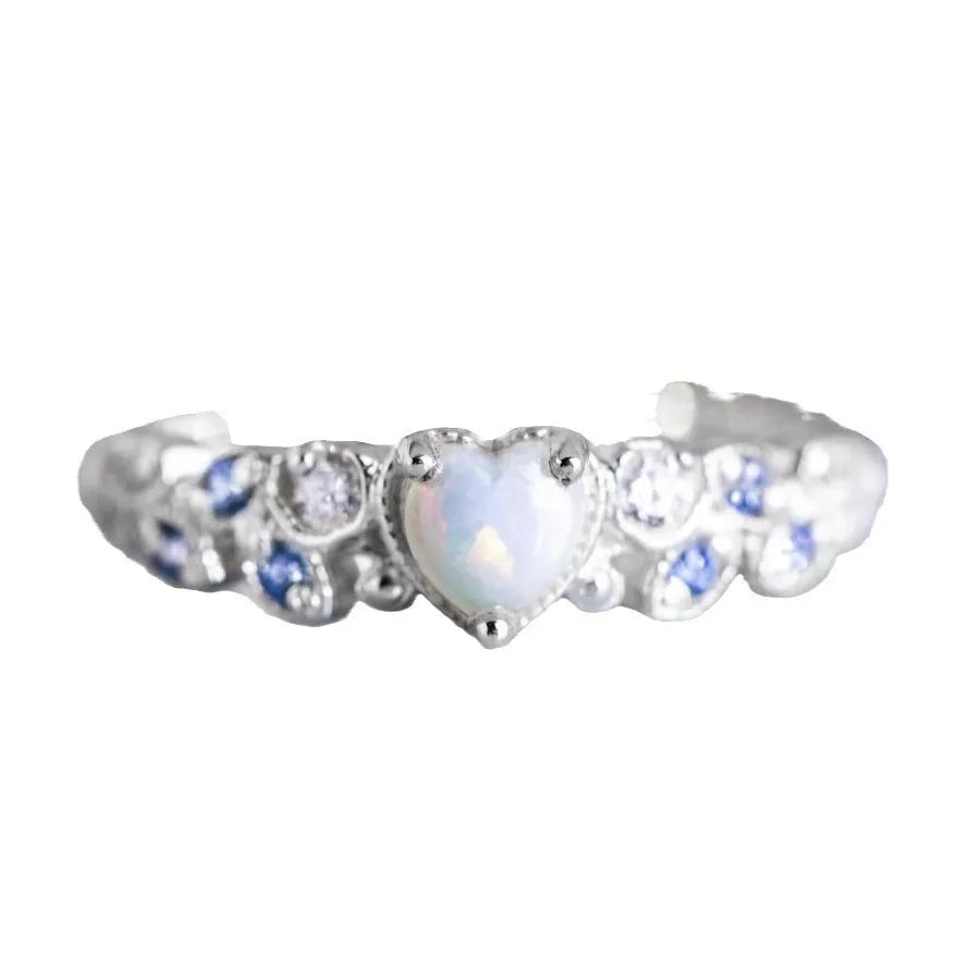 Close-up of a white alloy women's ring with a heart shape and flower opal ocean pattern detail.