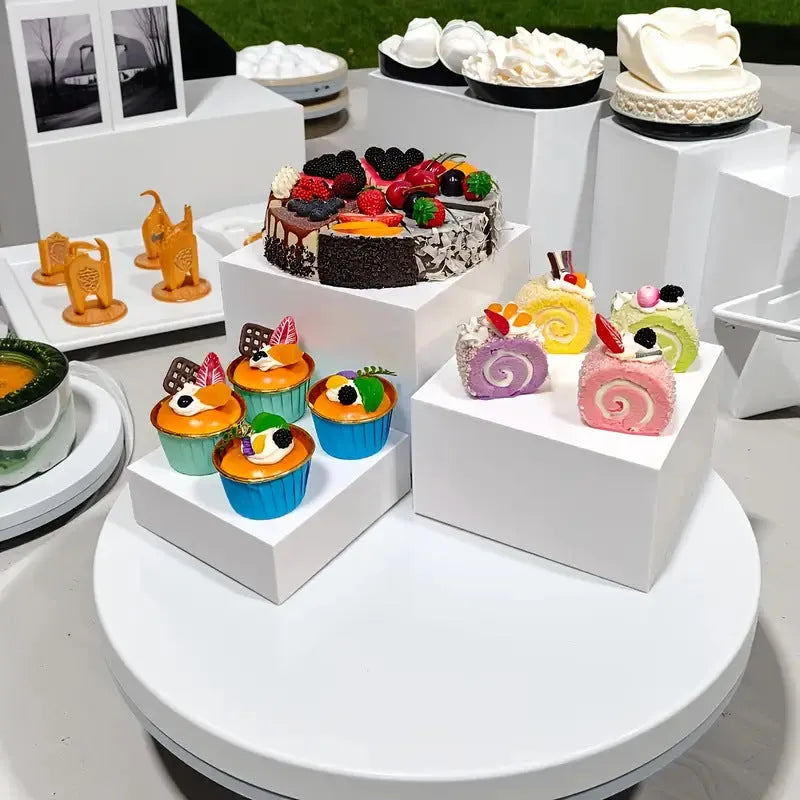 White plastic suit cube dessert display stand with six-piece arrangement for tabletop cake presentation