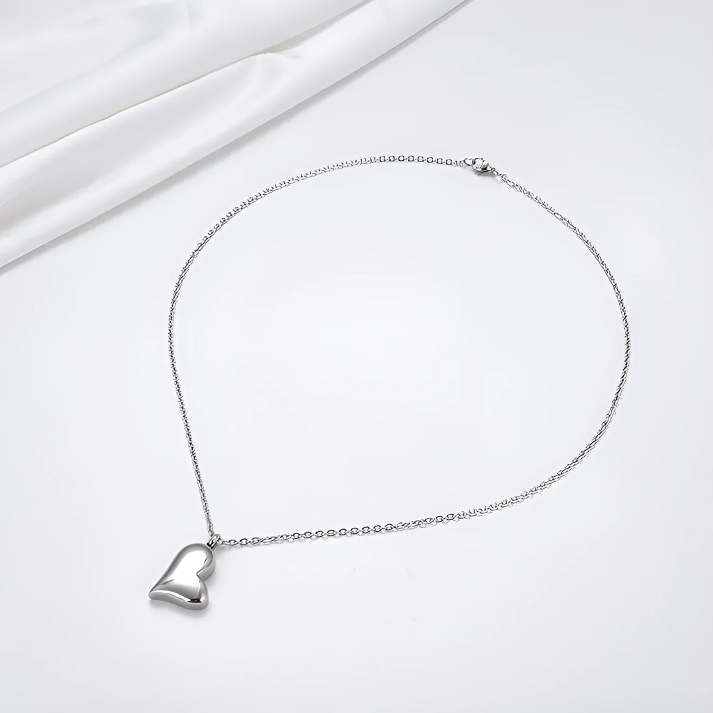 Silver curved peach heart pendant on a stainless steel necklace with extension chain