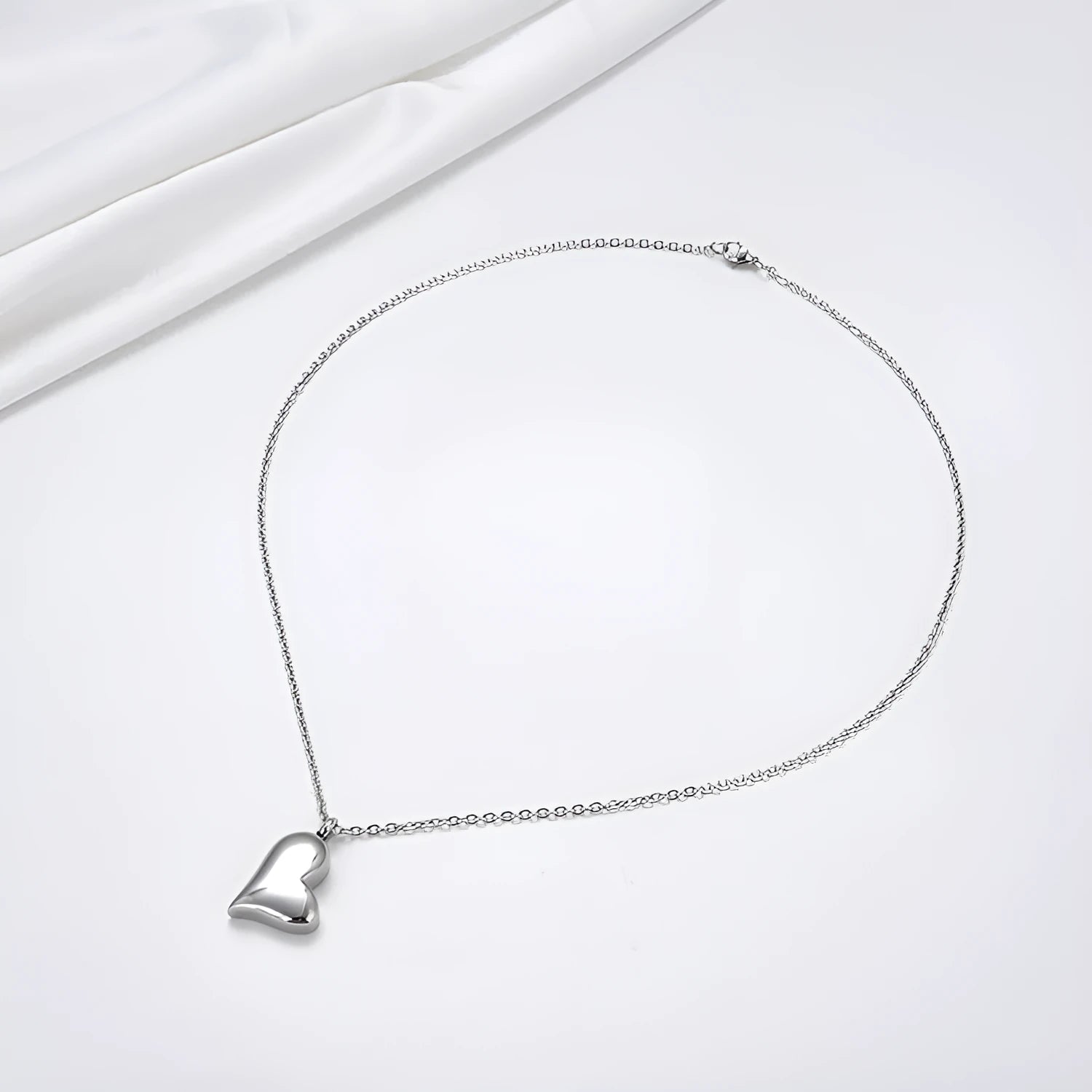 Silver curved peach heart pendant on a stainless steel necklace with extension chain