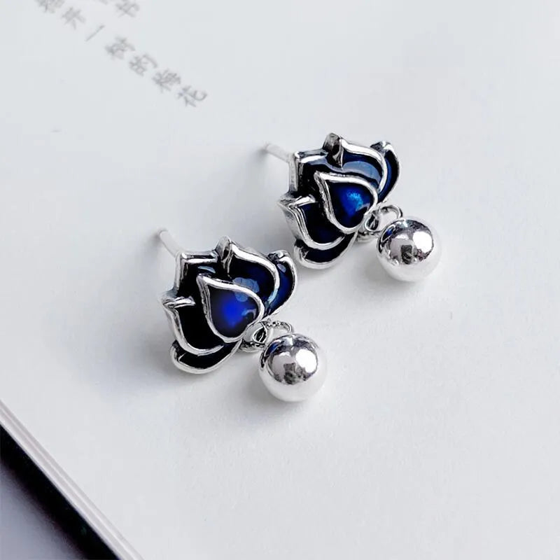 Close-up of alloy lotus ear studs with silver needle seedpod tassel design, showing 1.2cm width.
