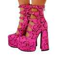Women's black patent leather platform high heels with a thick heel and ankle buckle strap.