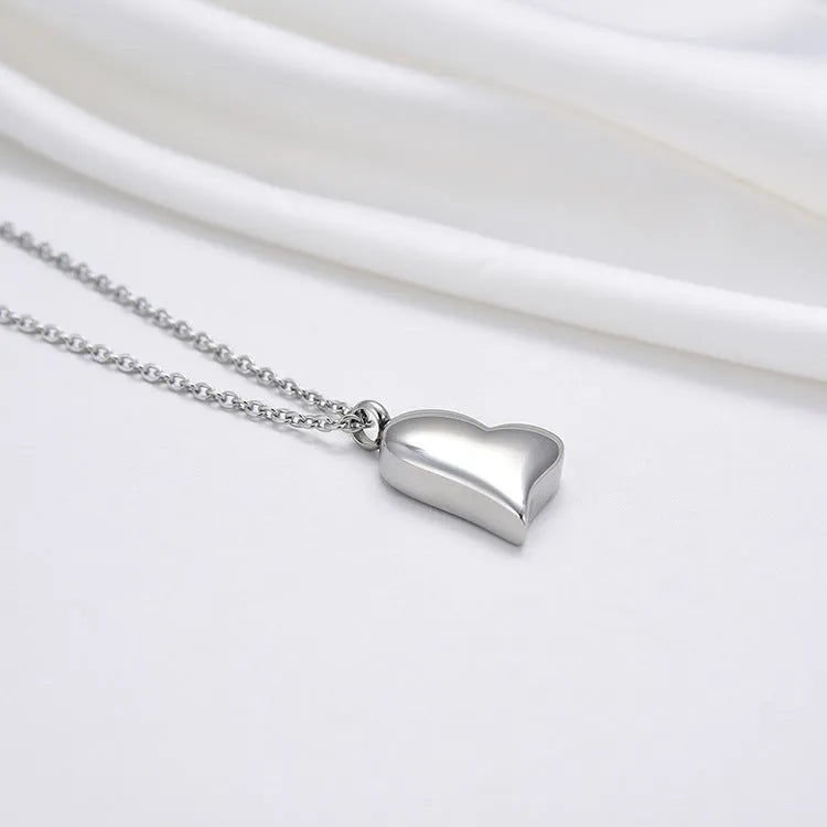 Silver curved peach heart pendant on a stainless steel necklace with extension chain
