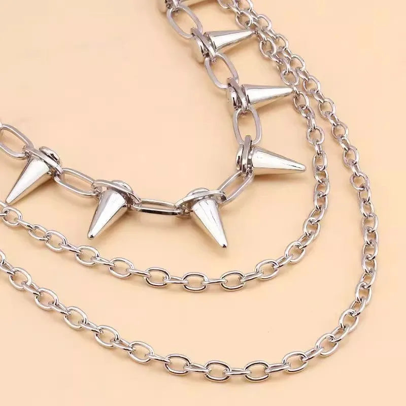 Silver metal punk pants chain with rivets and zipper detail, shown draped on trousers.