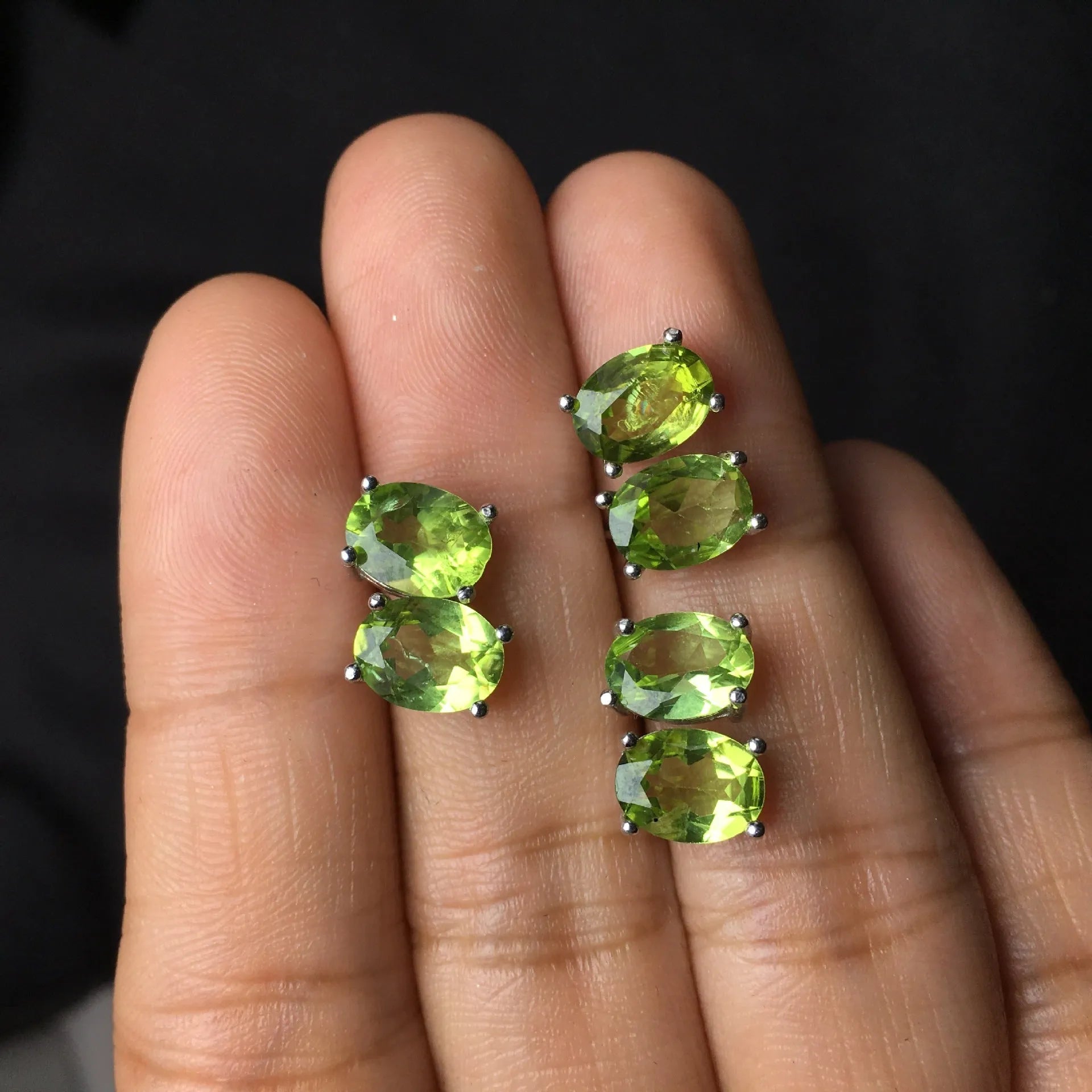 Natural grass green olivine faceted stud earrings set in S925 silver, showing oval stone shape.