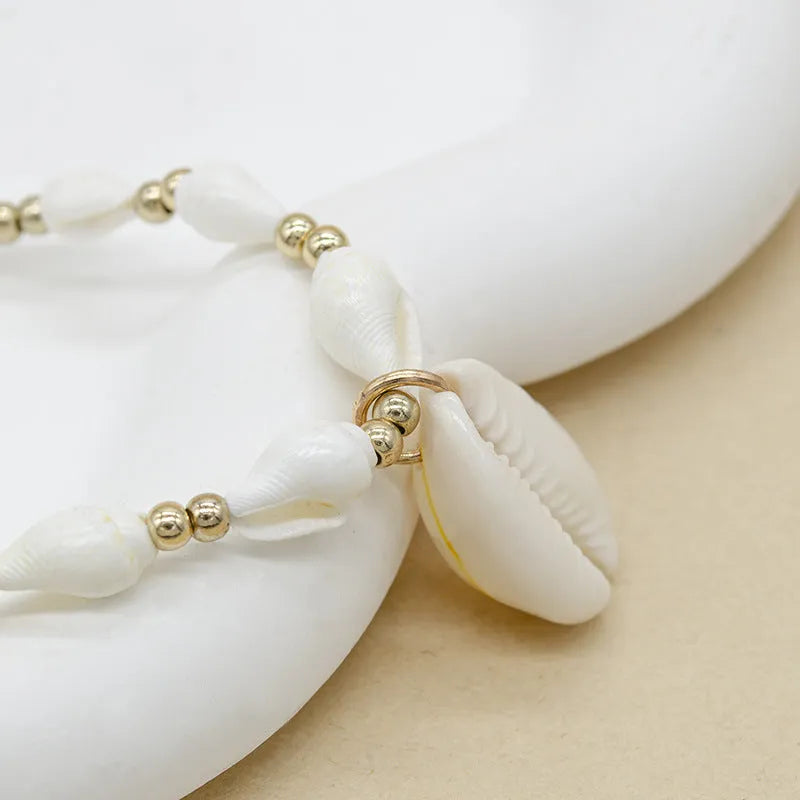 White conch shell pendant necklace with a cold wind pattern design on a silver-toned chain.