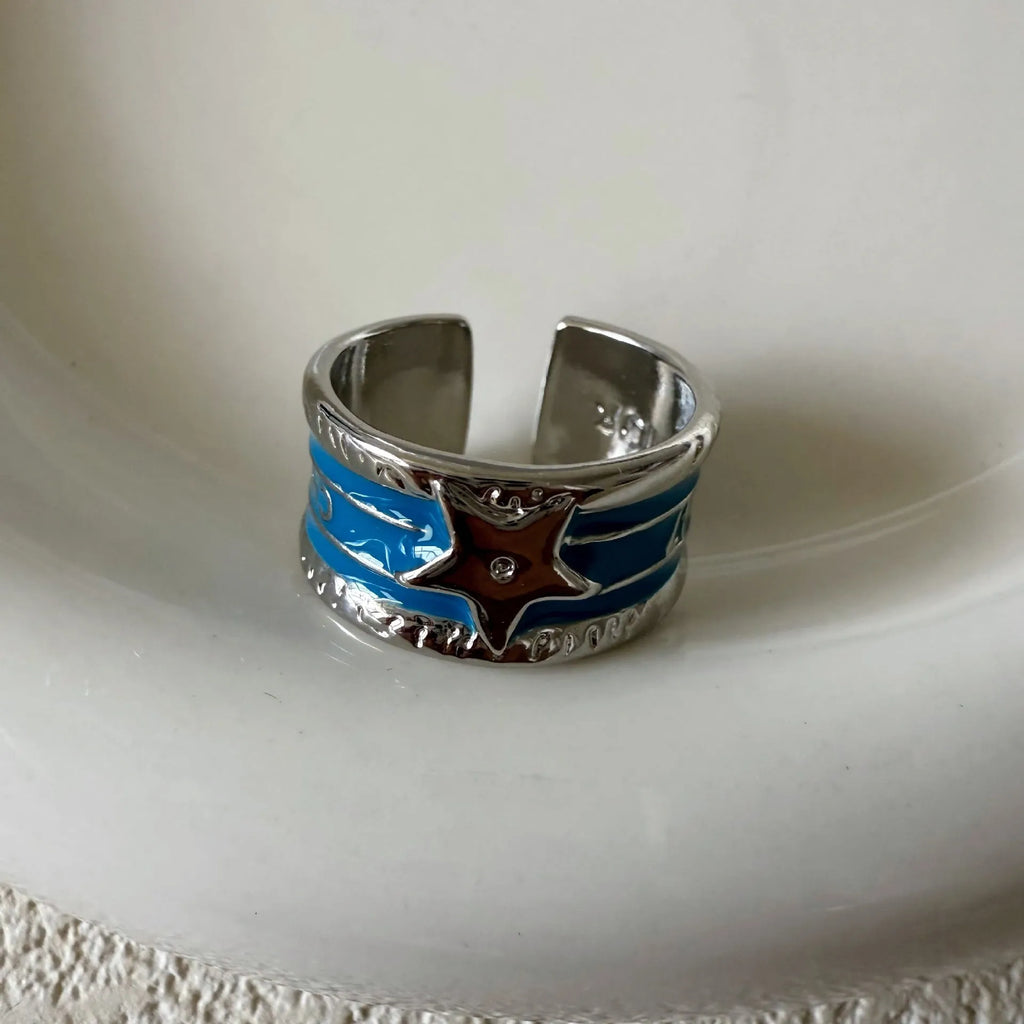 Geometric adjustable copper ring with a distressed finish in black, red, and blue colour options.