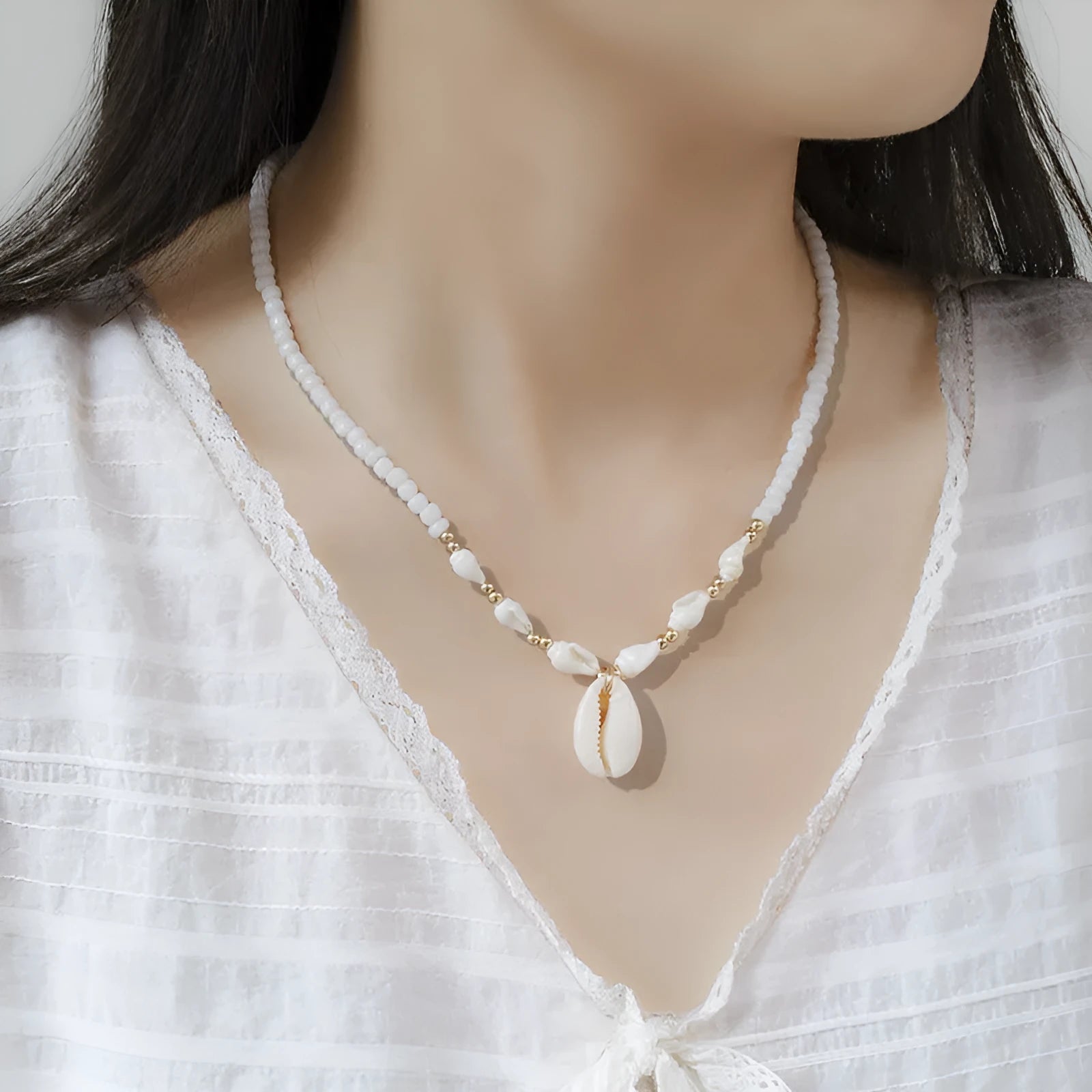 White conch shell pendant necklace with a cold wind pattern design on a silver-toned chain.