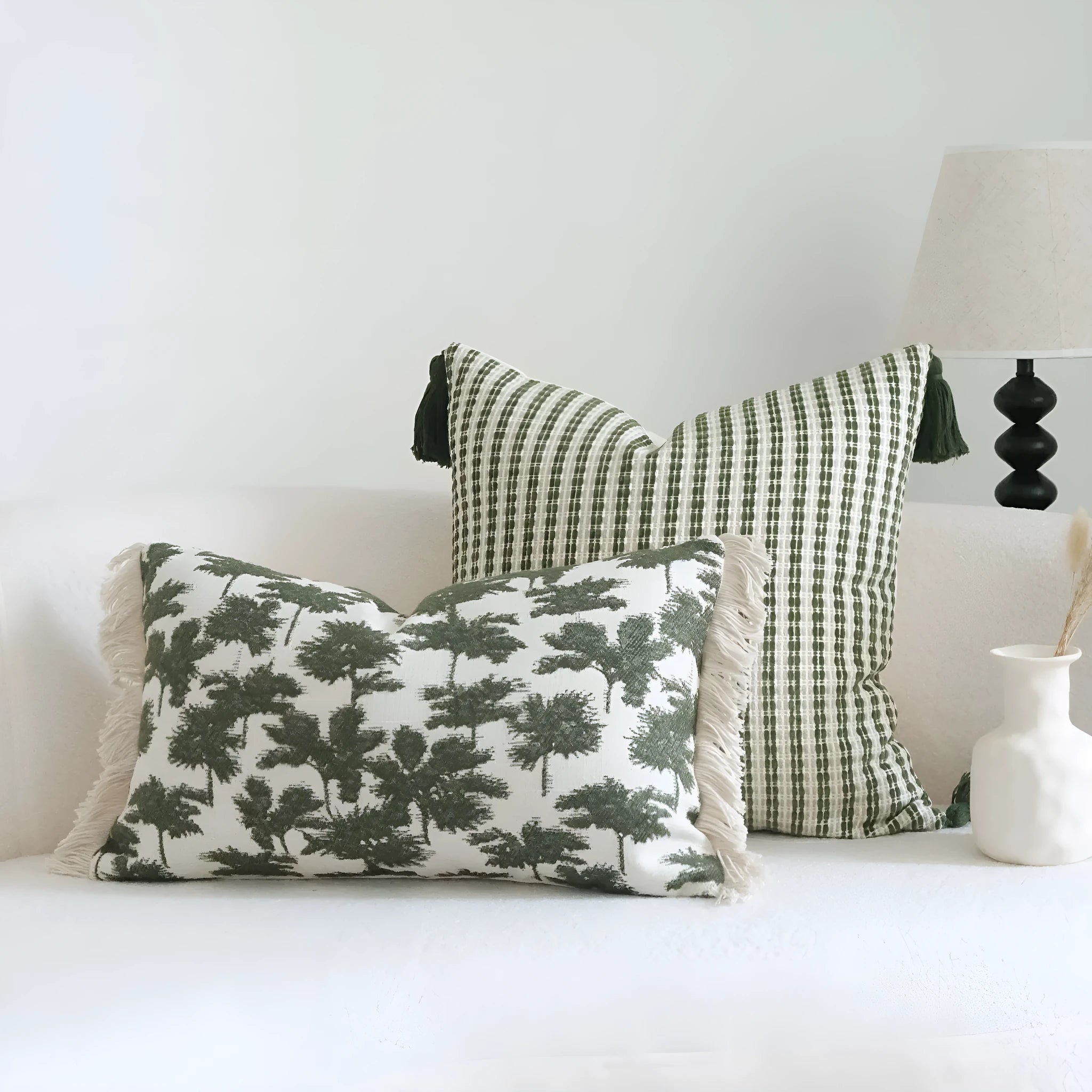 Green cotton linen hotel sample pillow with tassel design and silk floss filling on bed.