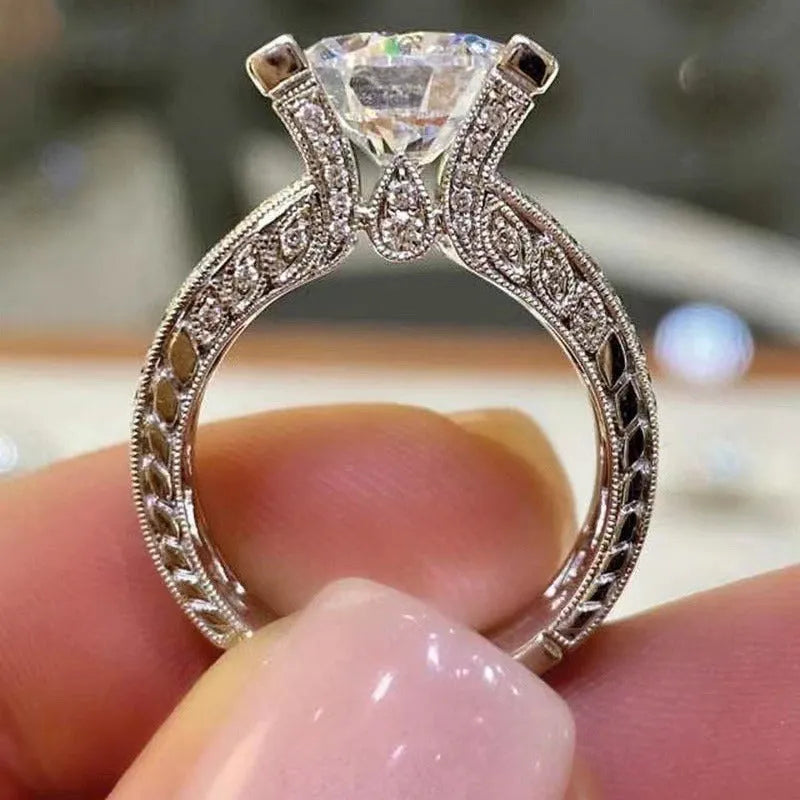 Geometric silver fashion engagement ring for women in gold or white electroplated finish on a size chart.