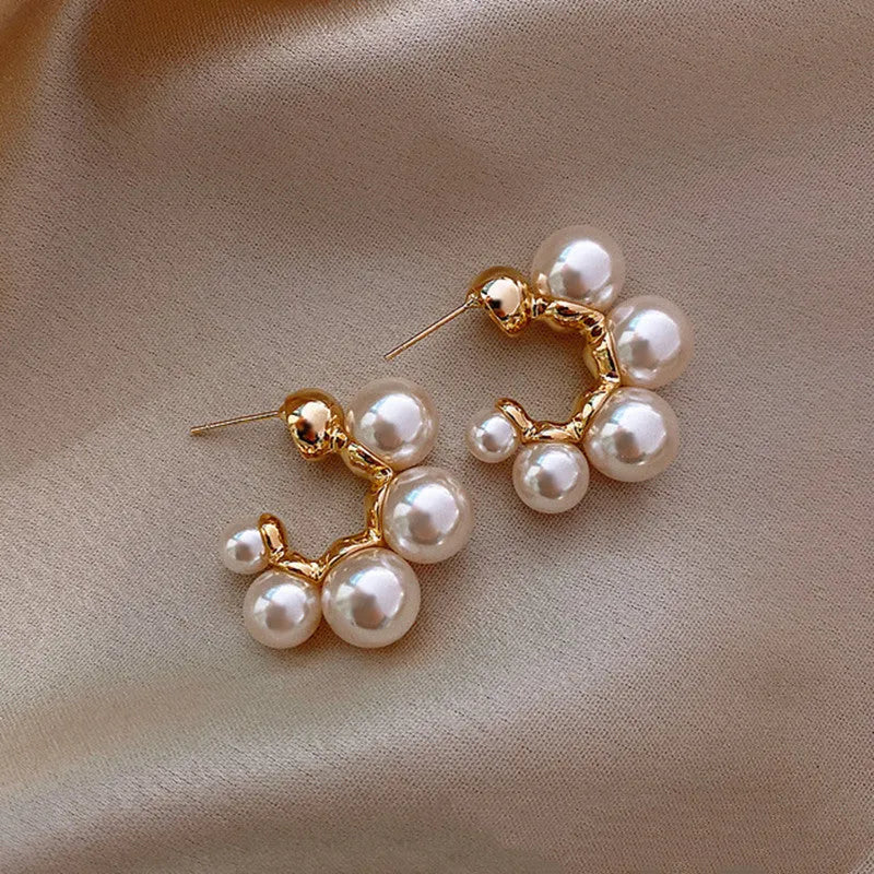 A pair of silver-tone alloy drop earrings with a red bell charm, shown against a plain background.