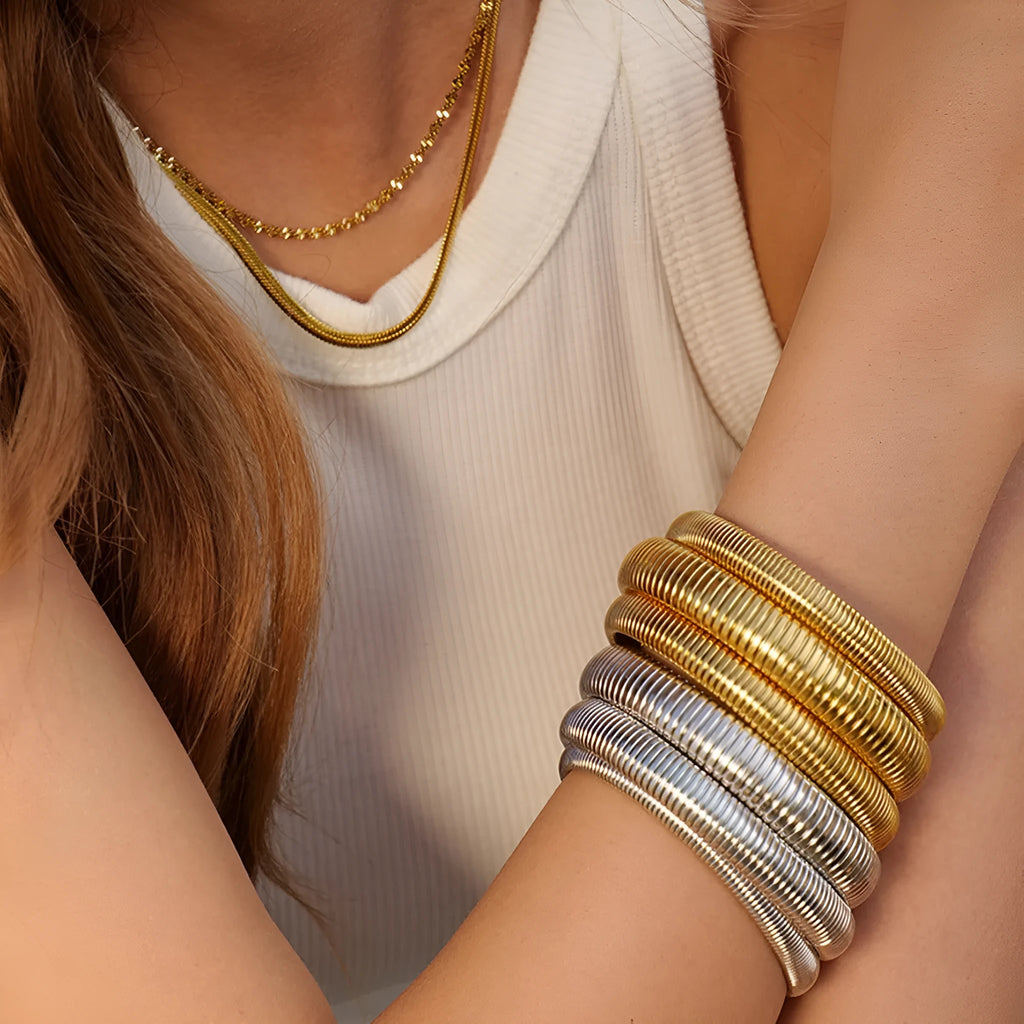Women's titanium steel elastic bracelet with vertical stripe pattern and ring element in gold finish