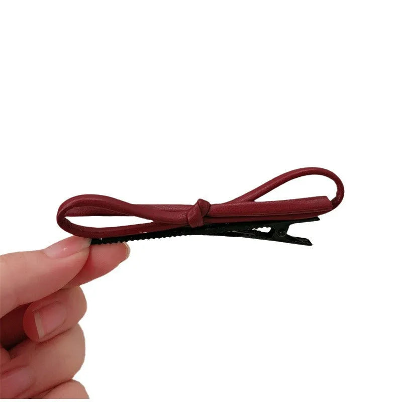 Wine red leather bow hair barrettes showing front and back views
