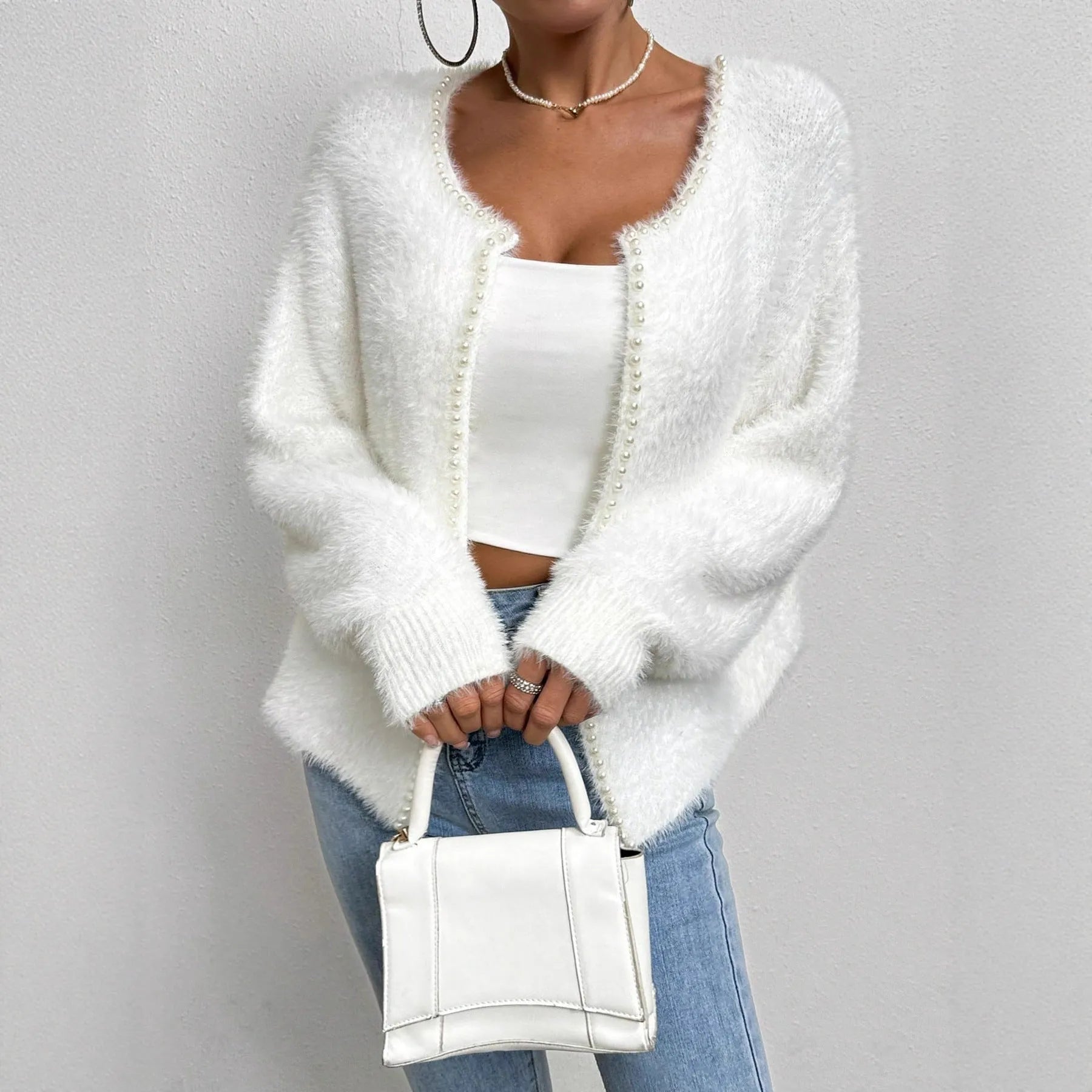 White women's V-neck cardigan sweater with bead knit texture on a hanger.