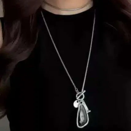 Long alloy sweater chain necklace with a geometric water drop pendant on a snake bone chain.