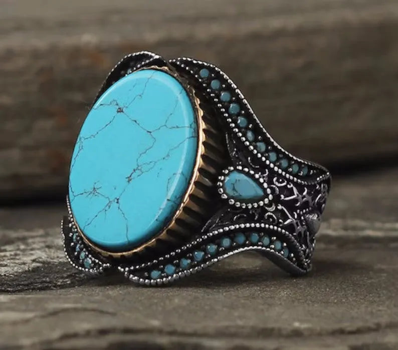 Men's antique silver turquoise ring showing round shape and polished metallic finish