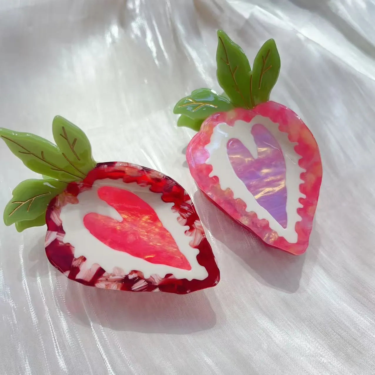 Handmade red strawberry hairpin with green leaves and a pink bow tie on a hair model.