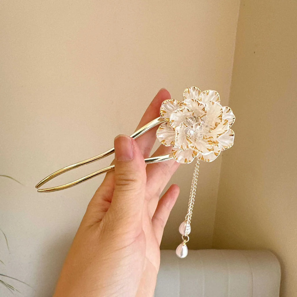 Close-up of a purple and white alloy U-shaped hairpin with a peony flower and tassel design.