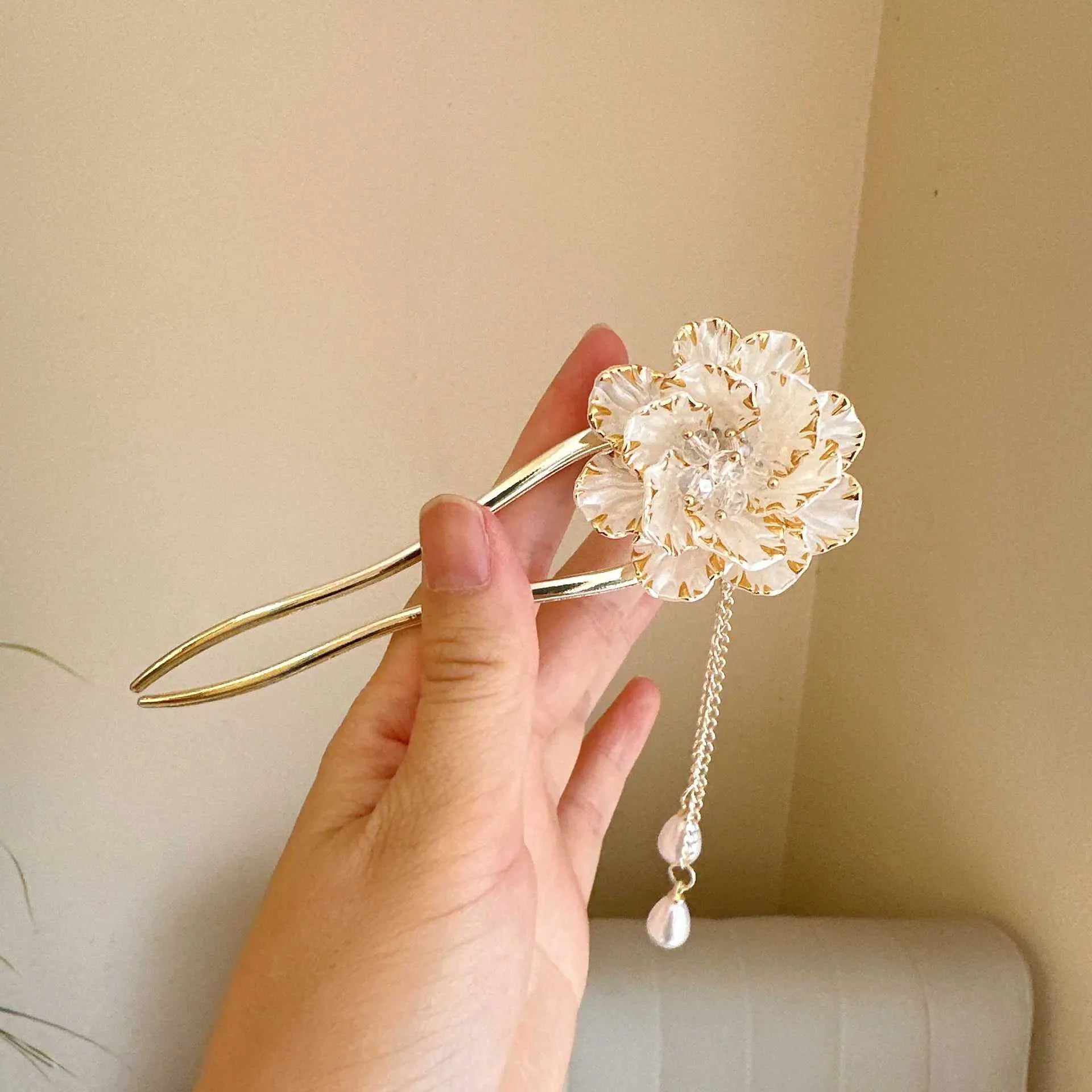 Close-up of a purple and white alloy U-shaped hairpin with a peony flower and tassel design.
