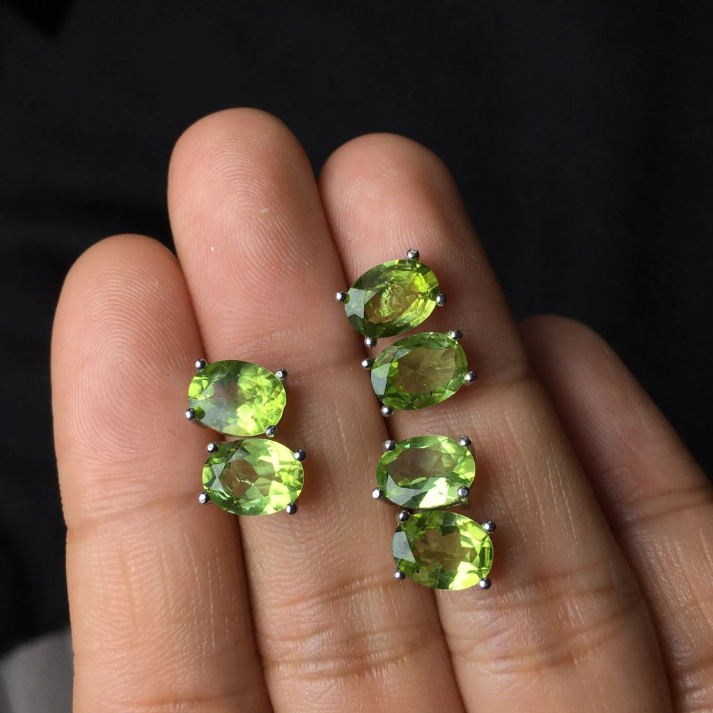 Natural grass green olivine faceted stud earrings set in S925 silver, showing oval stone shape.