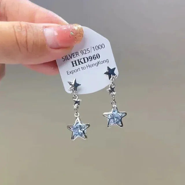 Geometric heart-shaped alloy ear clips with rhinestone accents and dangling star tassels in silver-tone