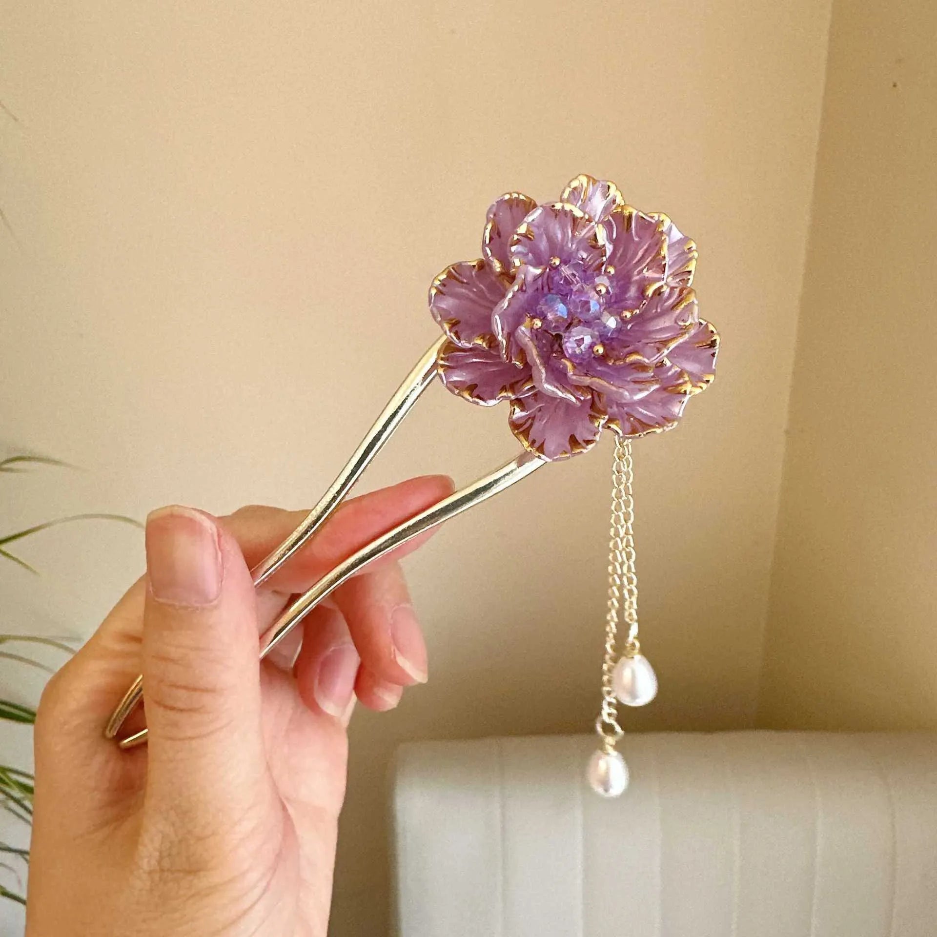 Close-up of a purple and white alloy U-shaped hairpin with a peony flower and tassel design.
