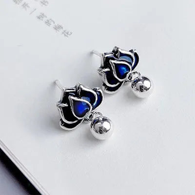 Close-up of alloy lotus ear studs with silver needle seedpod tassel design, showing 1.2cm width.