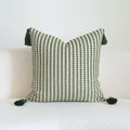 Green cotton linen hotel sample pillow with tassel design and silk floss filling on bed.