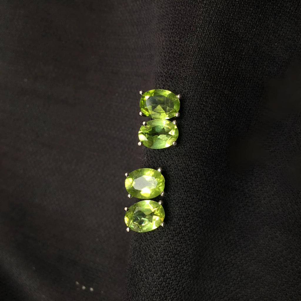 Natural grass green olivine faceted stud earrings set in S925 silver, showing oval stone shape.