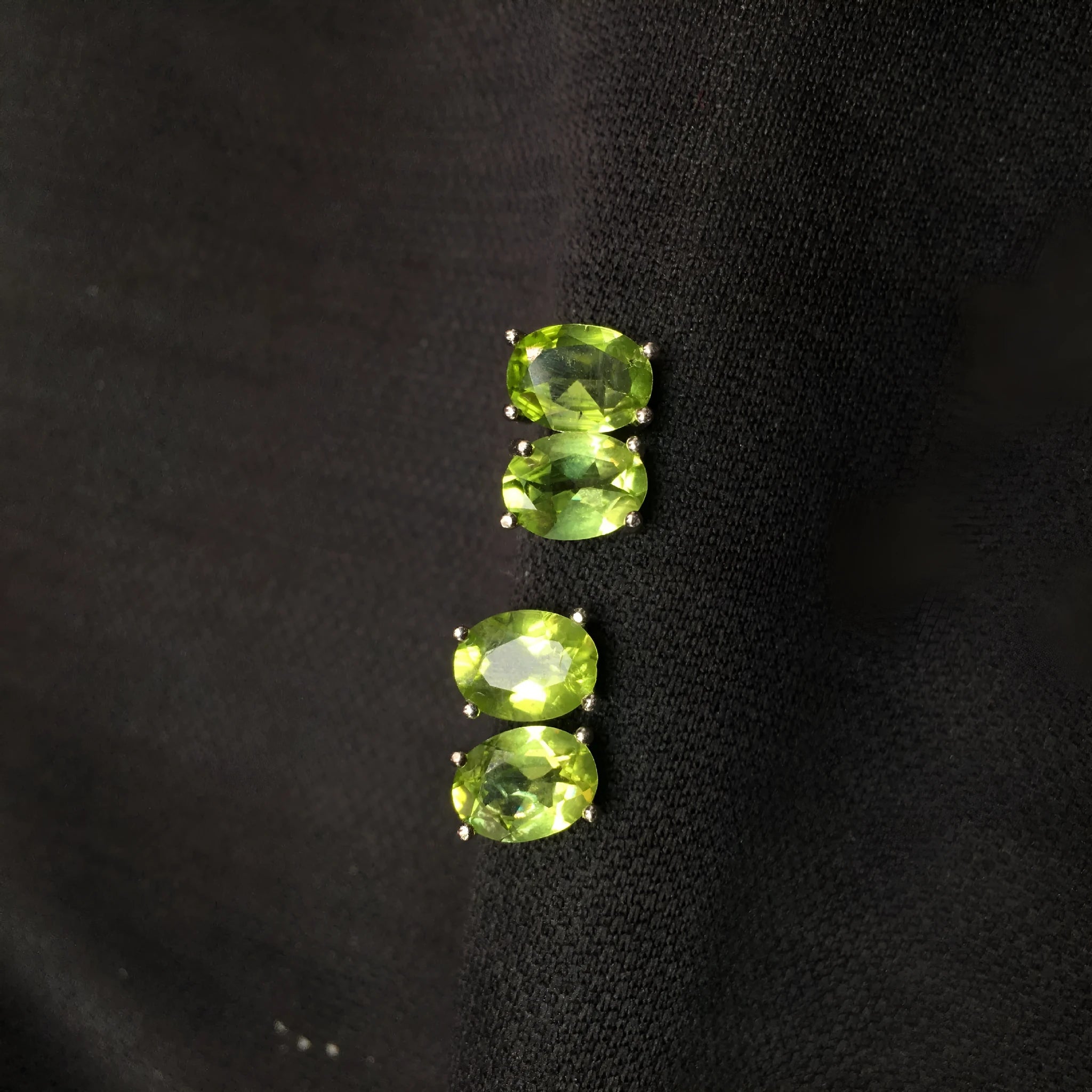 Natural grass green olivine faceted stud earrings set in S925 silver, showing oval stone shape.