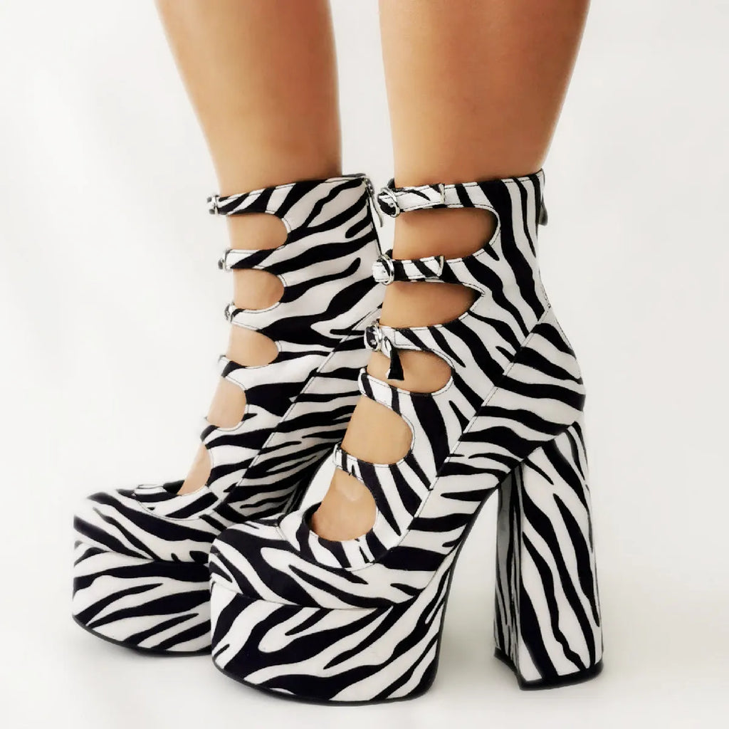 Women's black patent leather platform high heels with a thick heel and ankle buckle strap.